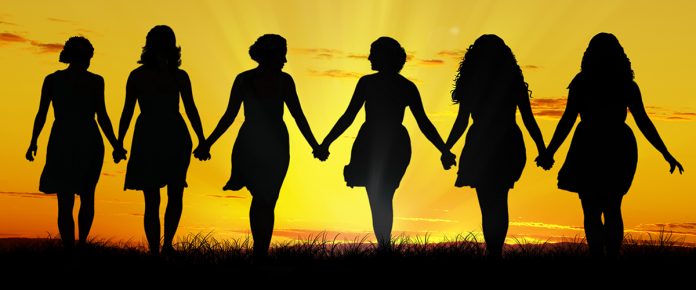 Silhouette of six young women, walking hand in hand
