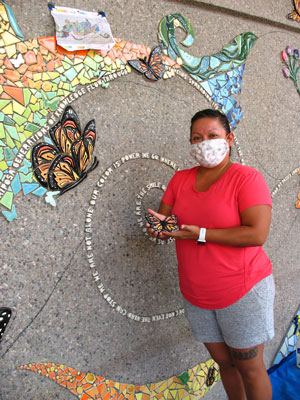ALMA Operations Director Margarita Paz-Pedro with the in-process mural and a butterfly.