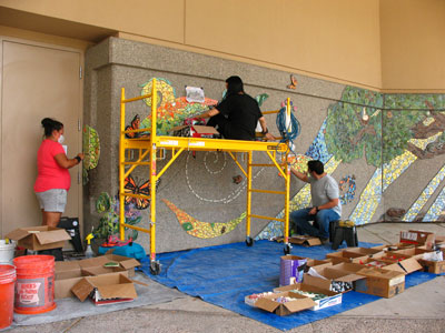 (l. to r.) Margarita Paz-Pedro, Tori Lucero and Atom Vigil work on the mural installation in July.