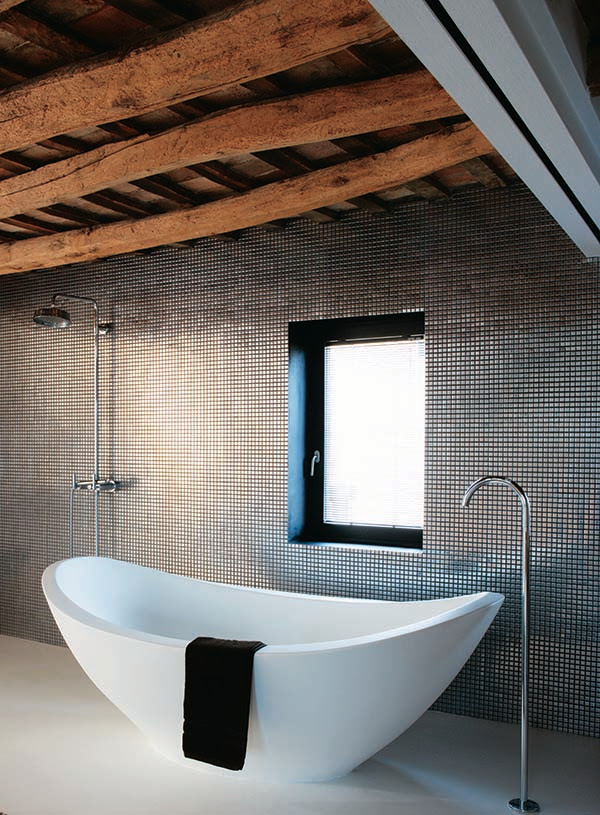 White bathtub in front of steel tile