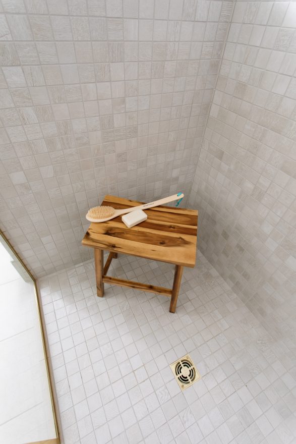 Wooden bench in tiled shower