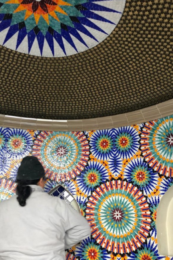 worker installing tile in pool grotto