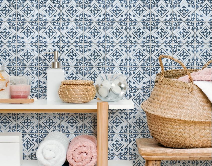 towel and bath items on shelf in front of blue tile