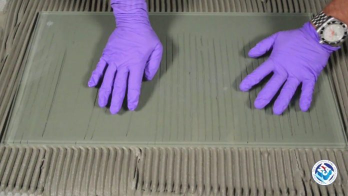 Gloved hands on glass over mortar