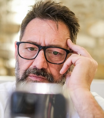 Man sitting at home, looking at his phone with a serious expression while reading a phishing scam notification. He struggles to comprehend the message, feeling confusion as he browses the web and searches social media