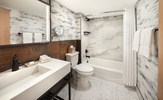 Panoramic gauged porcelain panels coordinate beautifully with birch bark look wallpaper for the Lodge rooms.