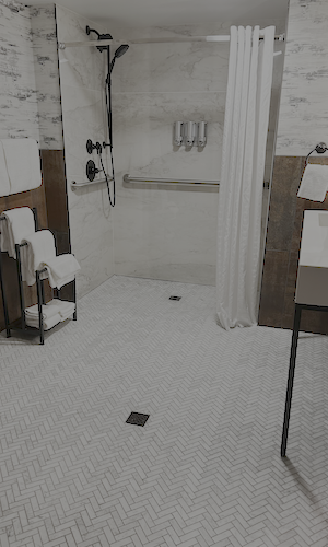 The HR Tile crew had a steep learning curve with the porcelain panels, but quickly perfected the technique. Panels in the shower coordinate beautifully with marble herringbone floors for an elegant ambiance.